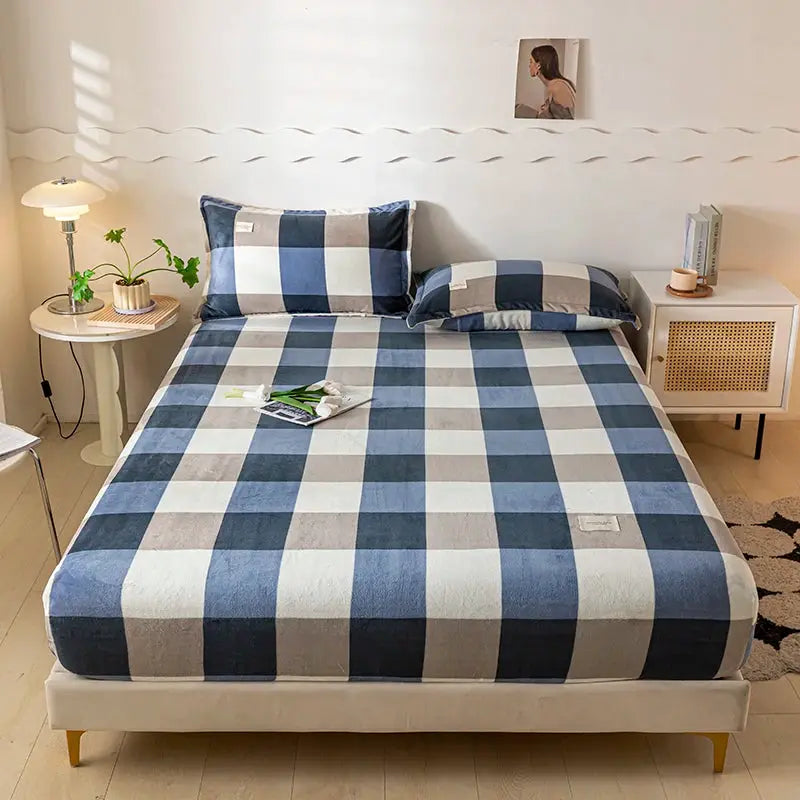 Velvet thermal mattress cover in blue and white plaid on a 120x200 bed with matching pillows