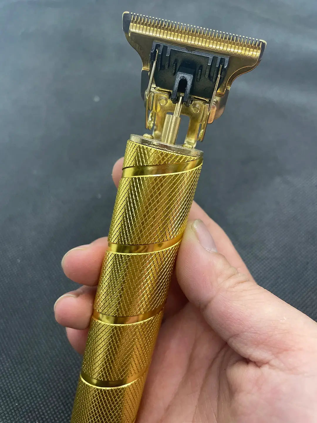Gold cordless men's electric hair trimmer with knurled gold handle.