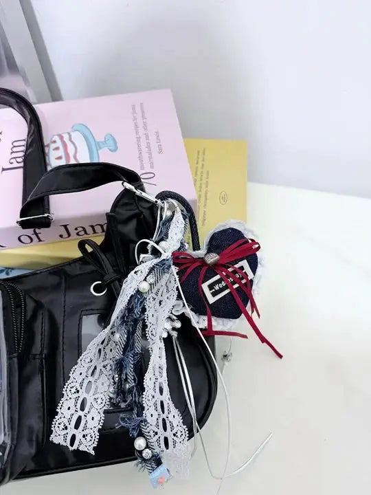 Y2k Harajuku shoulder bag in black with lace ribbons, denim charms and pearl bead embellishments.