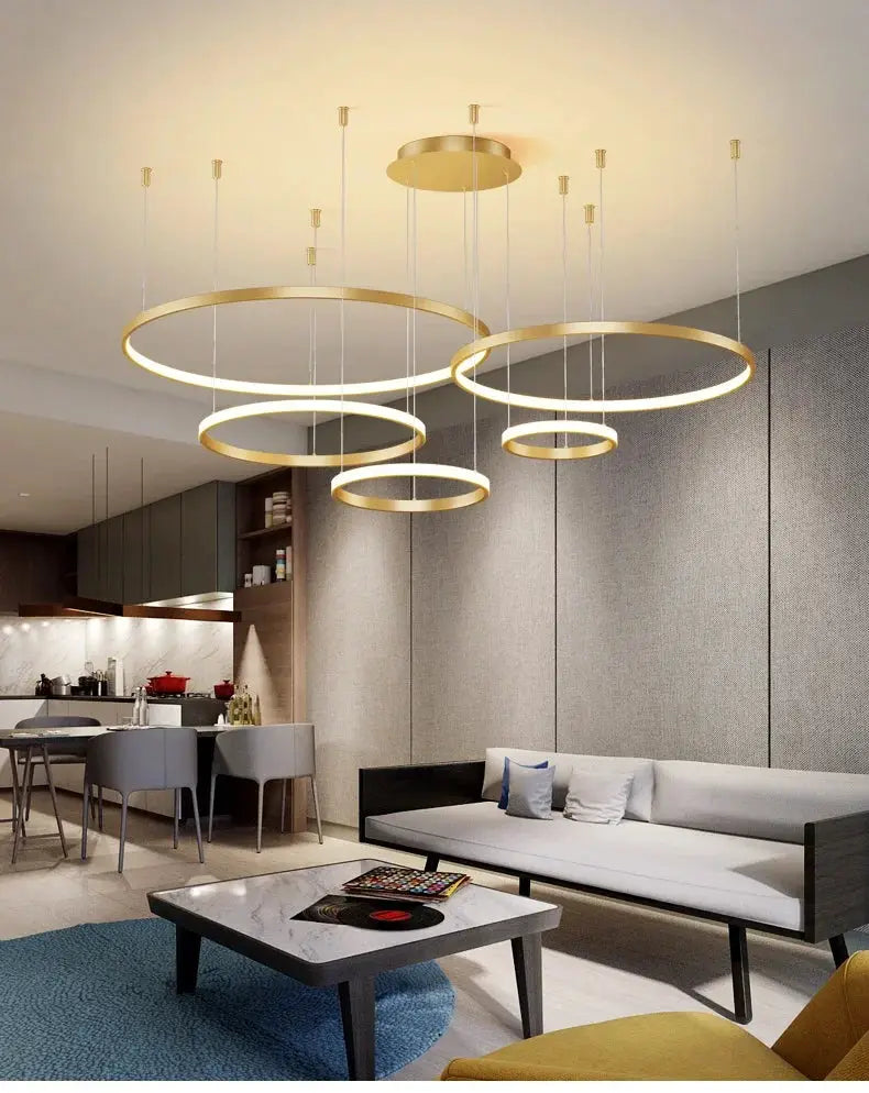 Ring pendant lights: five gold LED acrylic rings by Simples Market for a modern living room chandelier.