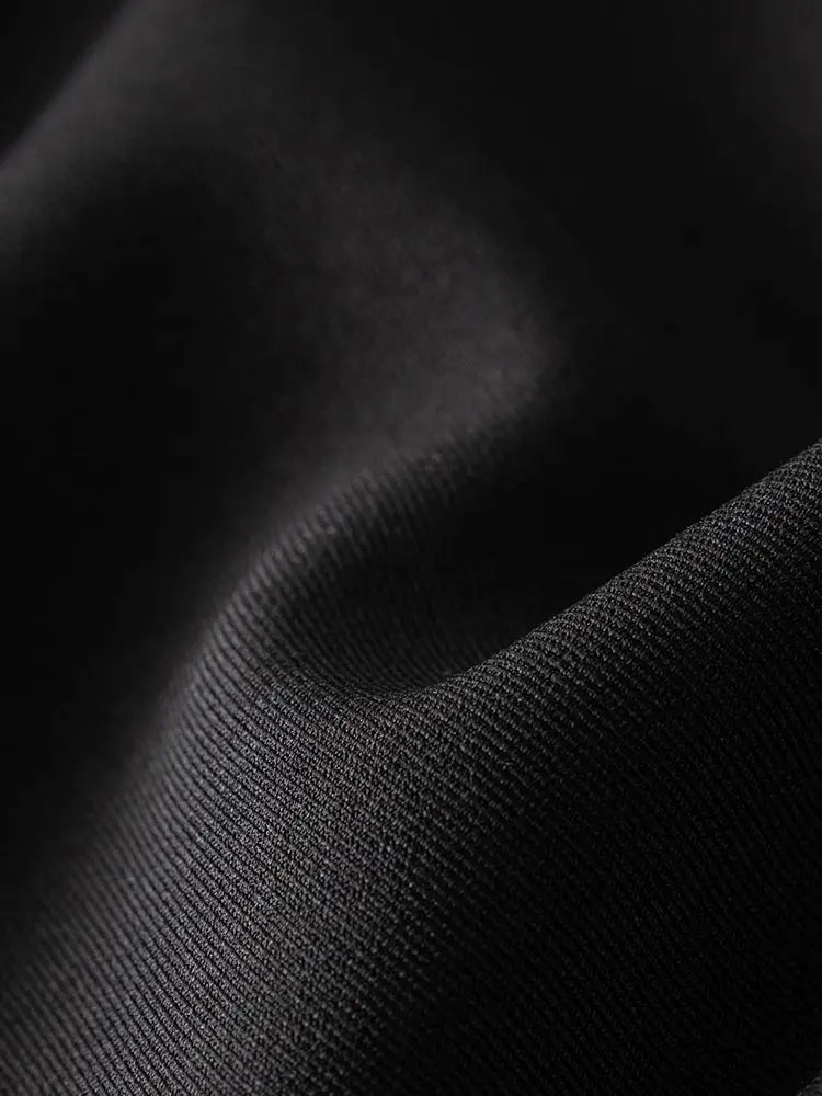 Women's blazer fabric close-up in black, smooth woven material