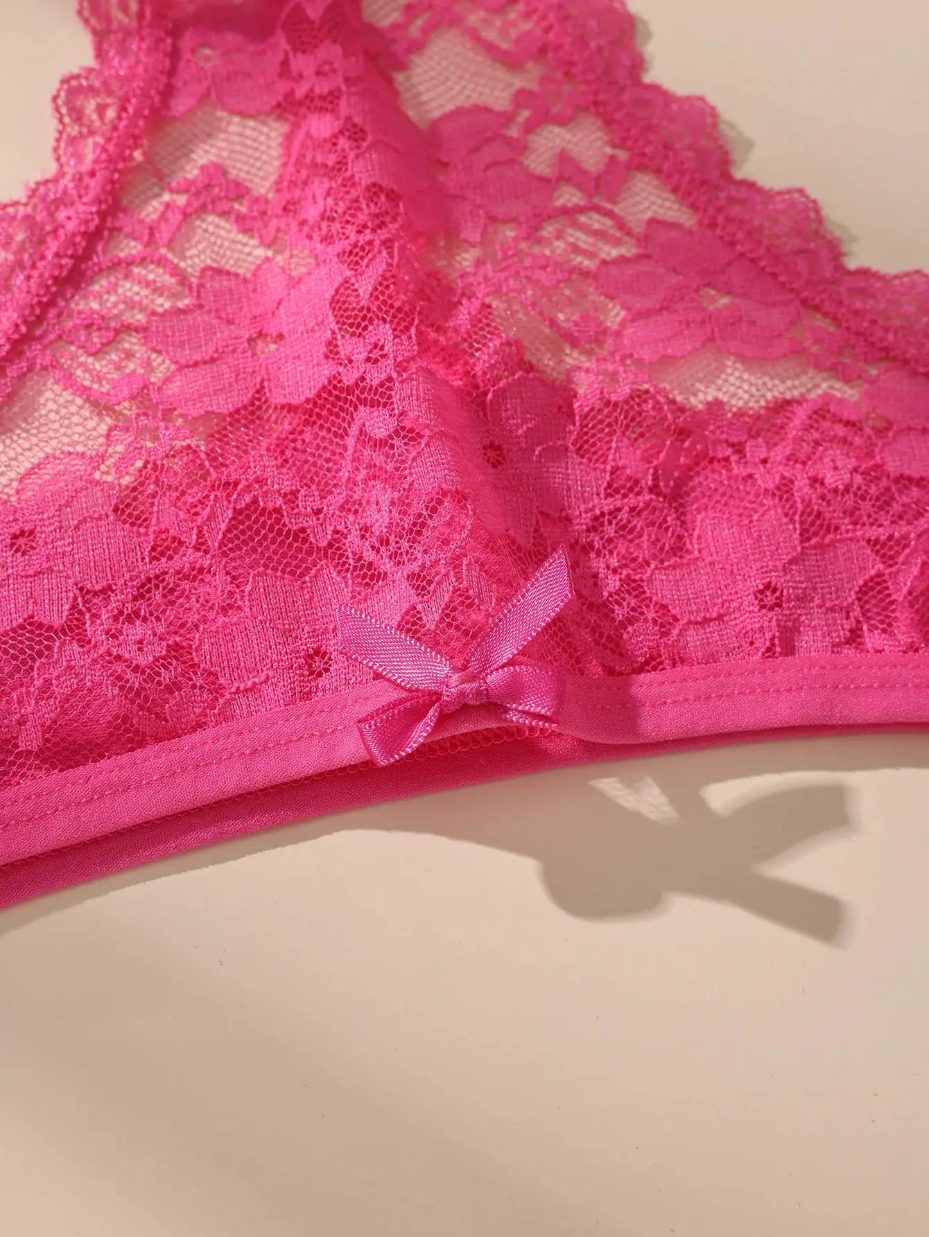 Pink lace bow underwear close-up; floral lace fabric with satin bow detail