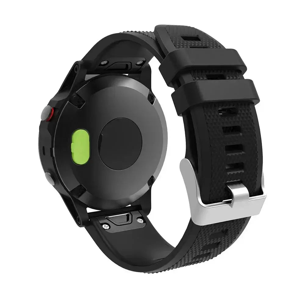 Garmin smartwatch with black textured silicone strap and silver buckle, rear view showing green sensor pad.