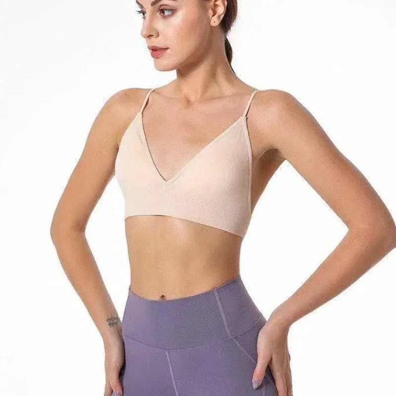 V-neck seamless triangle-cup bra camisole in nude, with thin straps, worn with purple high-waist leggings