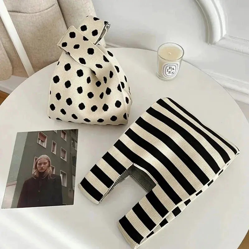Two fashion handbags: beige polka-dot hand-woven mini bag and black-and-white striped reusable shopping bag