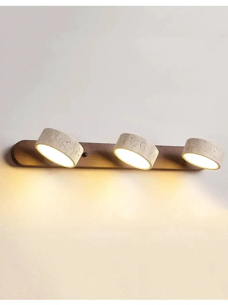 Triple round LED wall light with concrete-style heads on a wooden base, warm white illumination