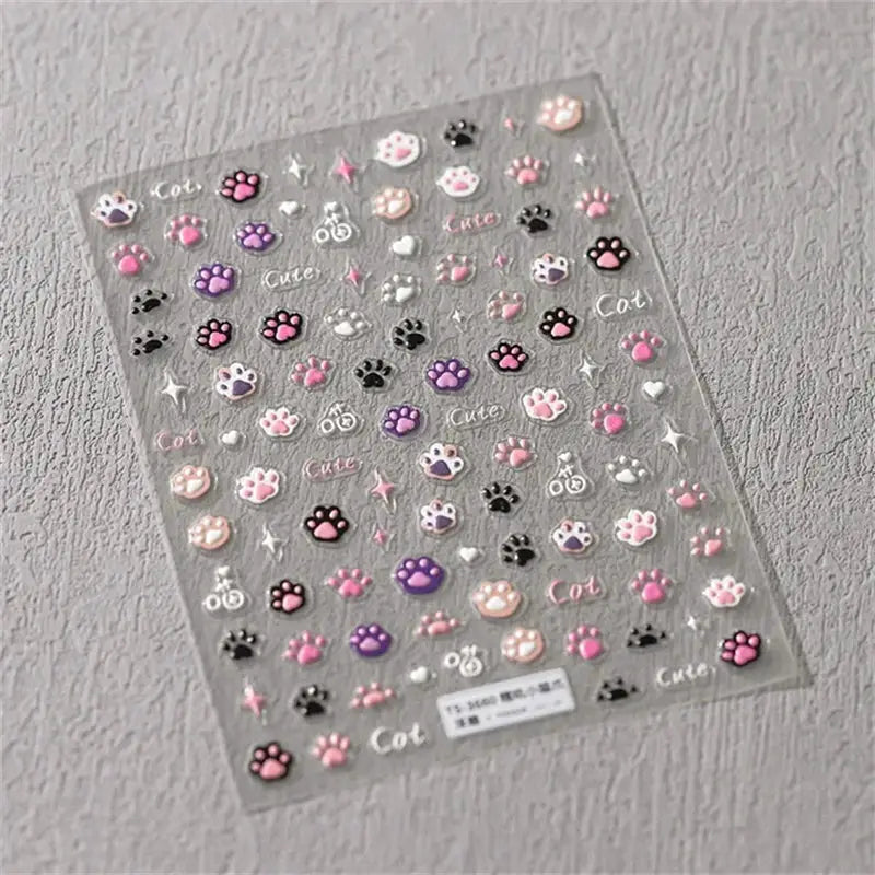 5D kawaii jelly nail art stickers sheet with pink, purple, beige and black paw print decals and cute icons for self-adhesive manicure