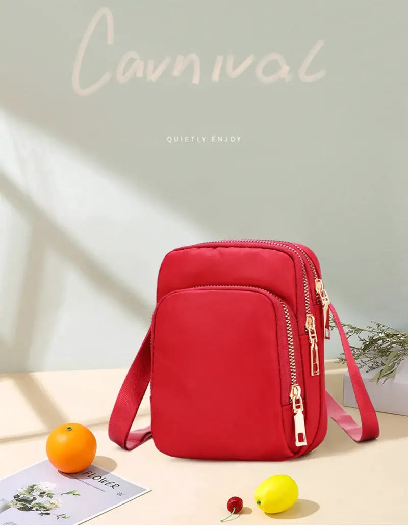 Red waterproof crossbody bag with multiple zip pockets and adjustable shoulder strap