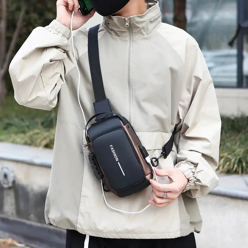 Men's anti-theft chest bag crossbody USB charging sling, black with brown trim worn across the chest.