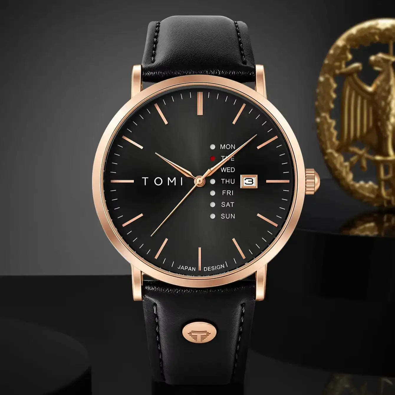 TOMI men's quartz watch with black dial, rose-gold case, black leather strap and weekday calendar with date window.