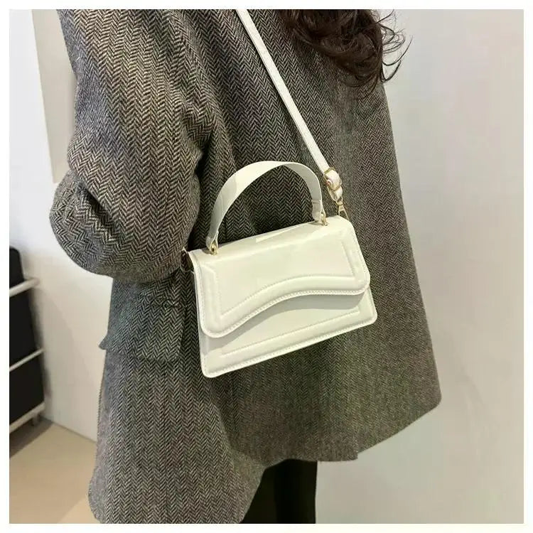 White PU leather handbag with top handle and long crossbody strap