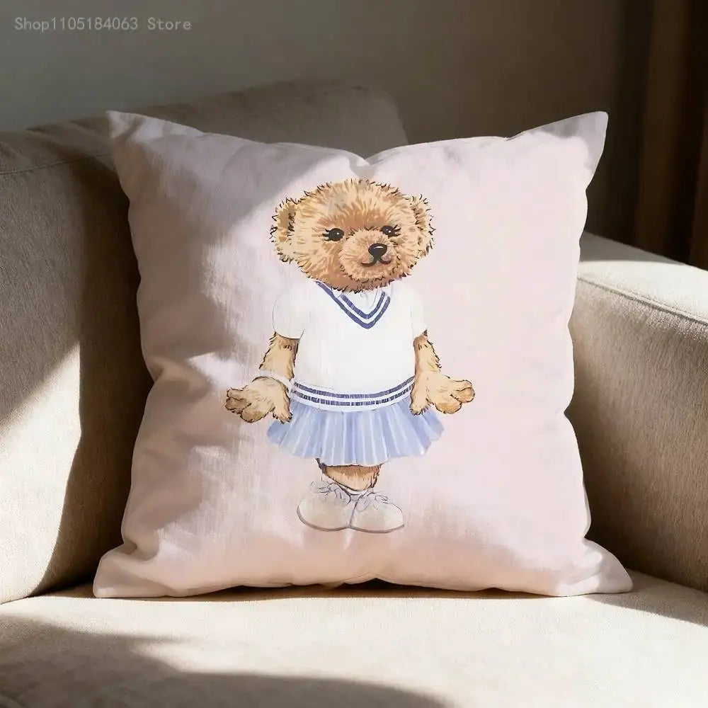 Bear-illustration throw pillow cover in pale pink with a teddy in a white top and blue skirt