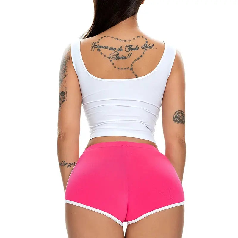 Hot pants pink shorts with white trim by Simples Market, back view of a woman in a white tank top