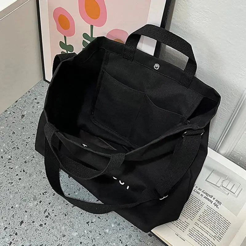 Canvas cross-body bag by Simples Market, black, large-capacity tote with top handles and interior pocket.