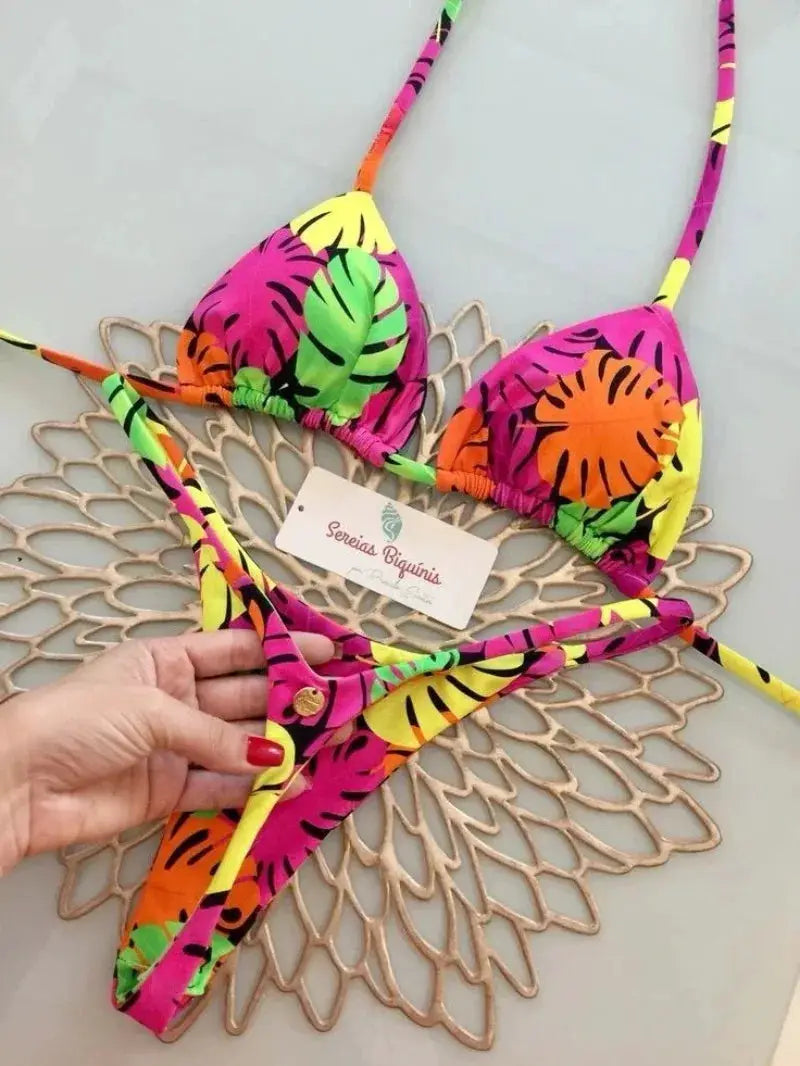Two-piece bikini set with neon tropical print halter top and thong bottoms