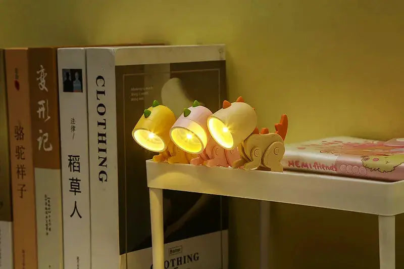 Mini night light LED cartoon hero police desk lamps, set of 3, yellow figures on a white shelf beside books.