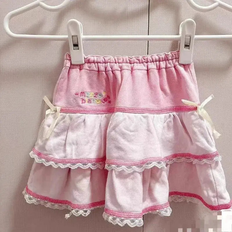 Sweet Lolita cake mini skirt in pink and white with lace-trimmed tiers, bow accents, and embroidery.