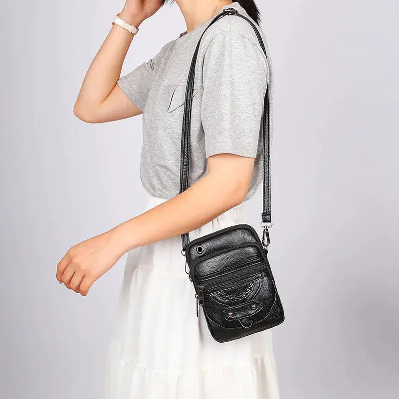 Women's black PU leather messenger bag with front pocket and crossbody strap by Simples Market.
