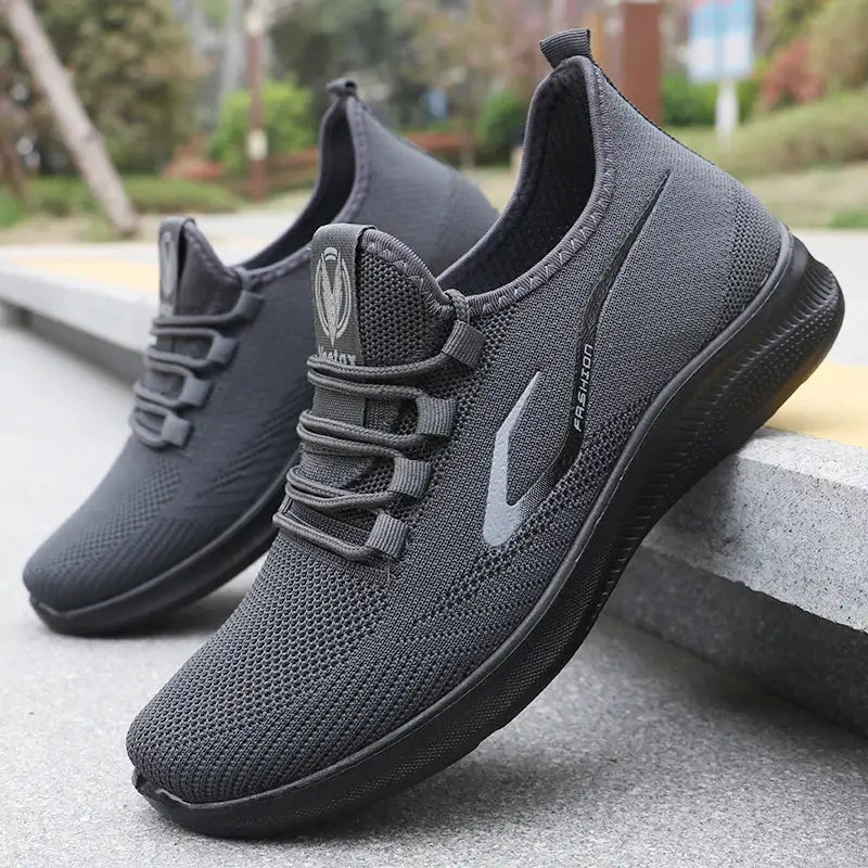 Pair of men's black knitted running shoes with grey logo, breathable mesh, non-slip sole