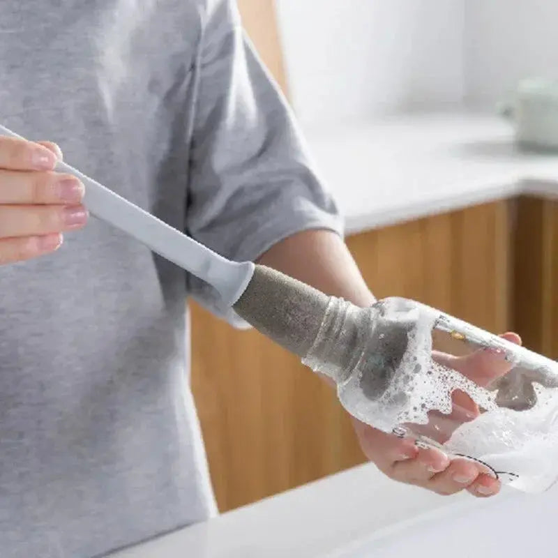 Long-handle sponge cup brush with gray handle from Simples Market cleaning a bottle with soap suds