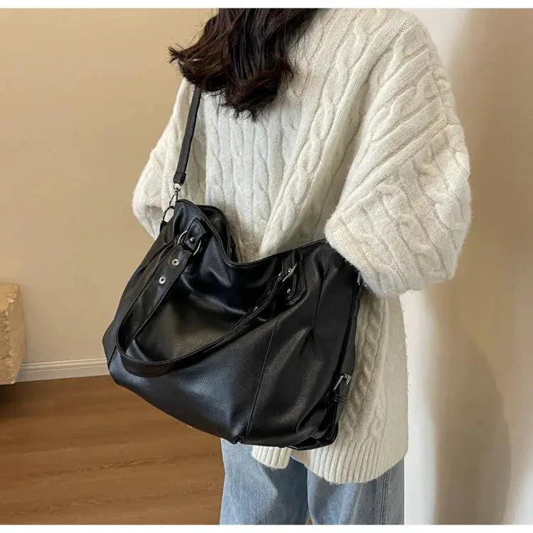 Soft interior compartment shoulder bag in black PU leather with dual handles and crossbody strap