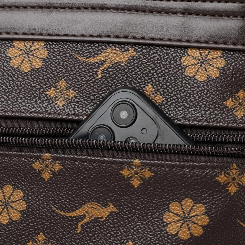 Ladies leather backpack in brown with gold floral print; smartphone visible in front pocket.