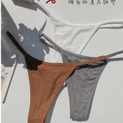 Three cotton seamless thongs in white, camel brown, and gray; low-rise rib-knit design