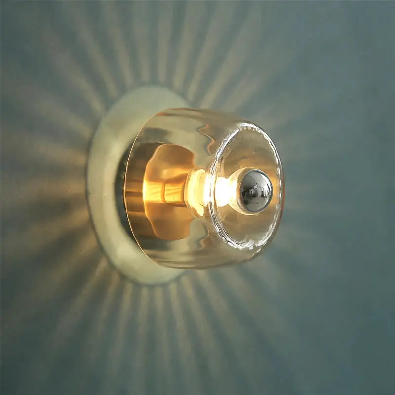 LED Bauhaus glass wall lamp with clear cylindrical shade and warm glow, wall-mounted
