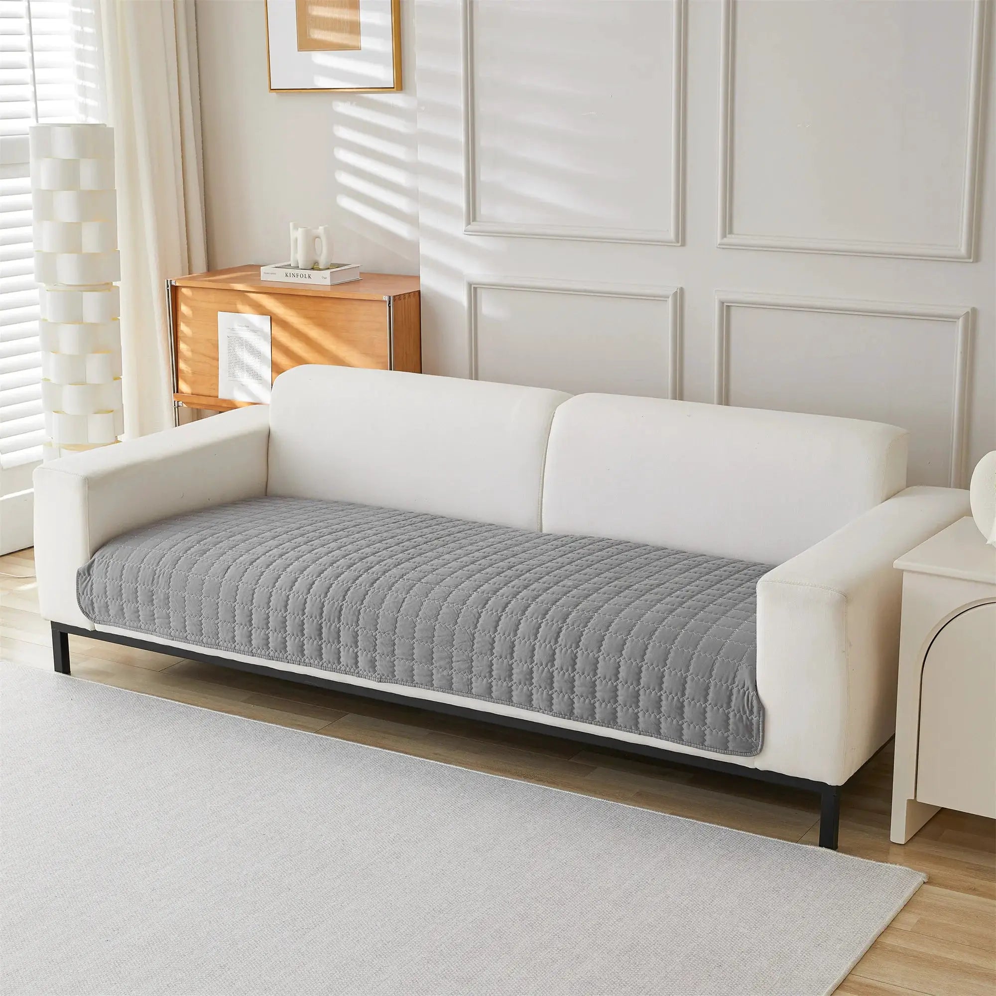 Sofa cover, 1pc plain quilted anti-slip in gray on a white sofa in a bright living room