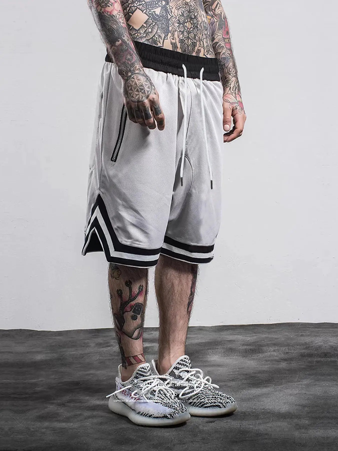 Men's white mesh quick-dry basketball shorts with black elastic waistband, white drawstrings and zip pockets