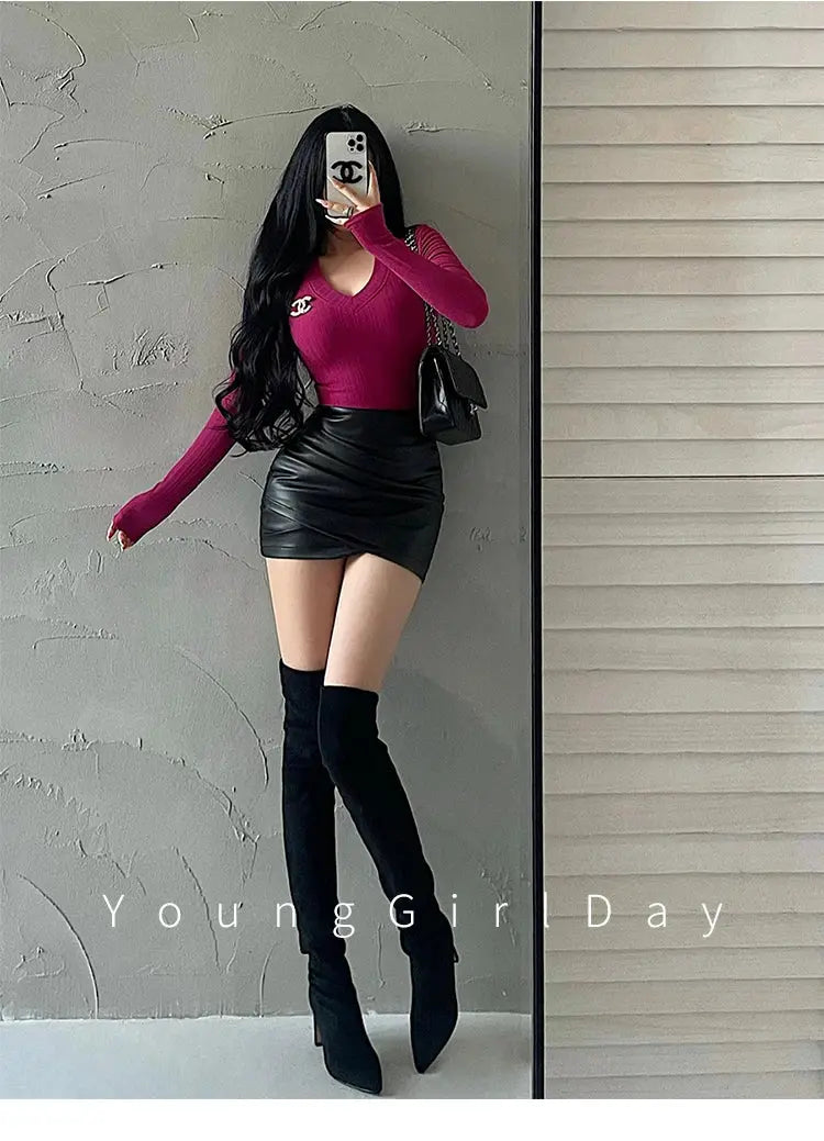 Women's black PU leather mini skirt with high-waist wrap; magenta knit top with Chanel logo, black handbag, knee-high boots