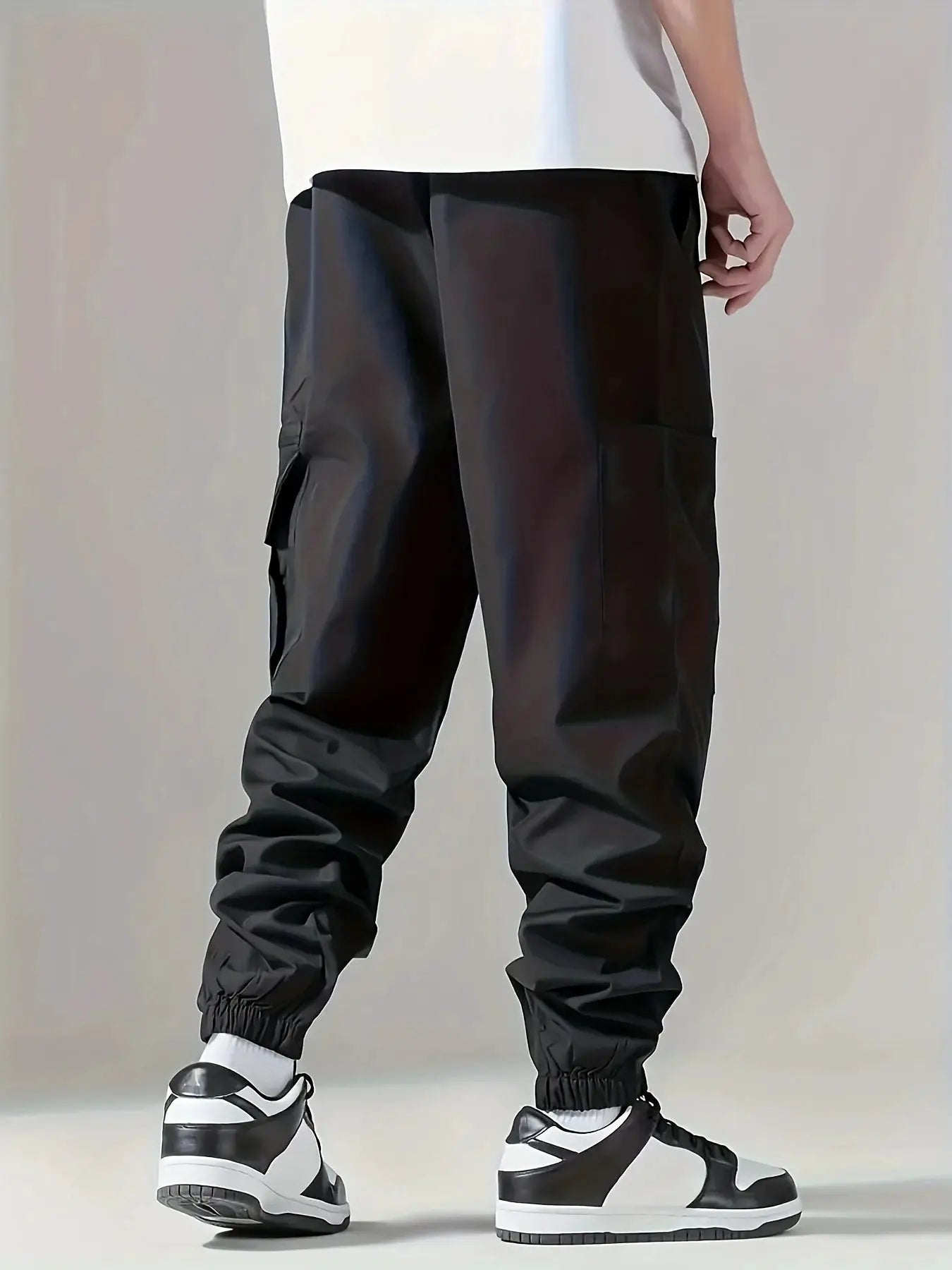 Men's black cargo pants with multiple pockets and elastic cuffs for outdoor wear