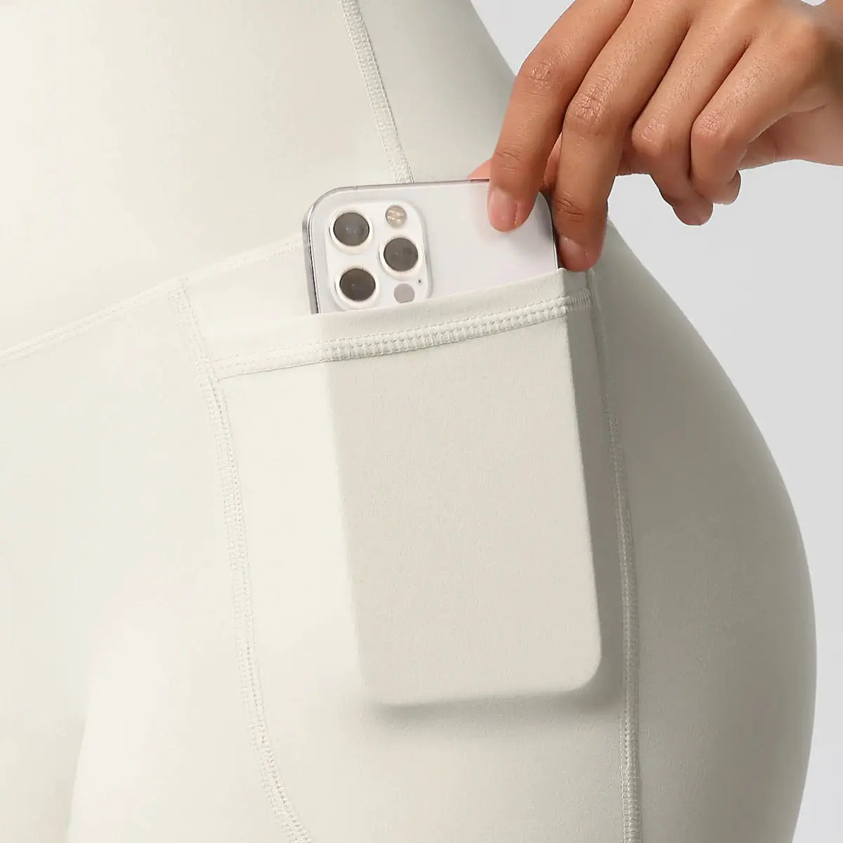 Women’s pocketed yoga shorts in cream white with a secure side pocket; ideal for workouts and gym training.