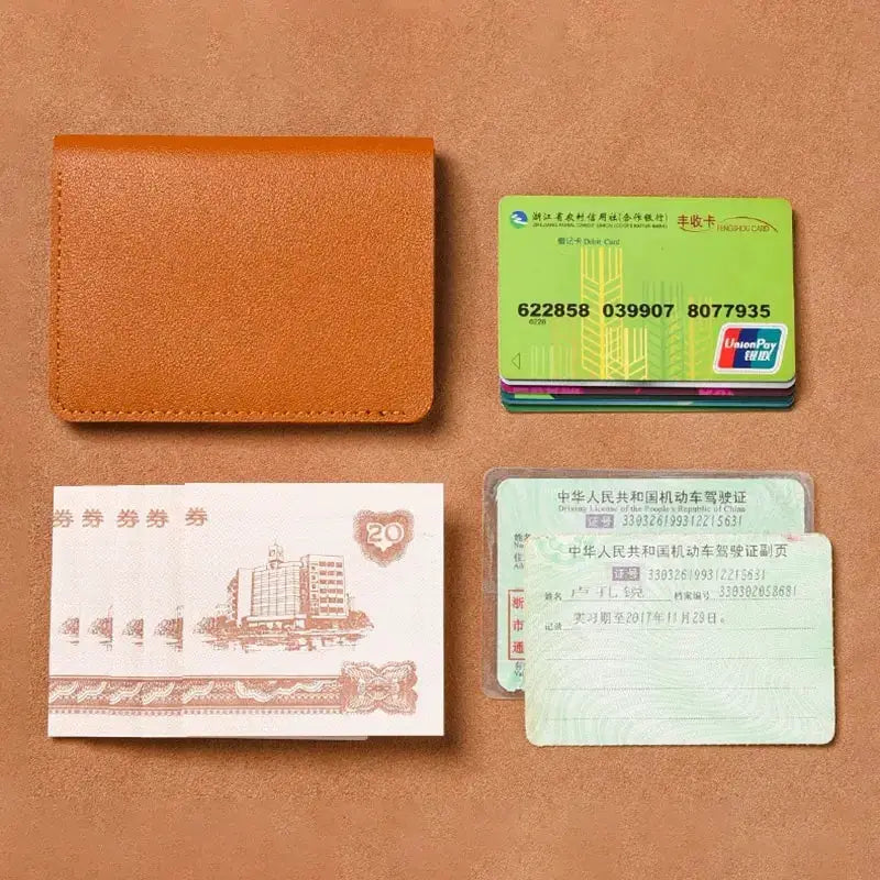 Tan PU leather compact wallet with card slots and coin pouch, shown with a stack of colorful cards.