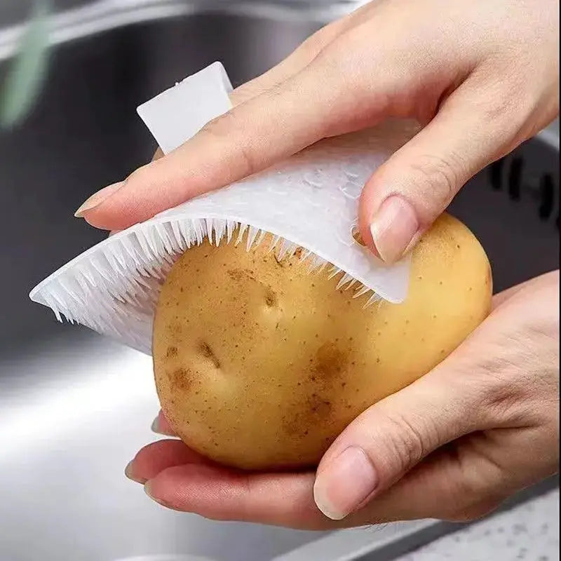 Silicone dish scrubber crevice brush; white, for fruits and vegetables, used on a potato