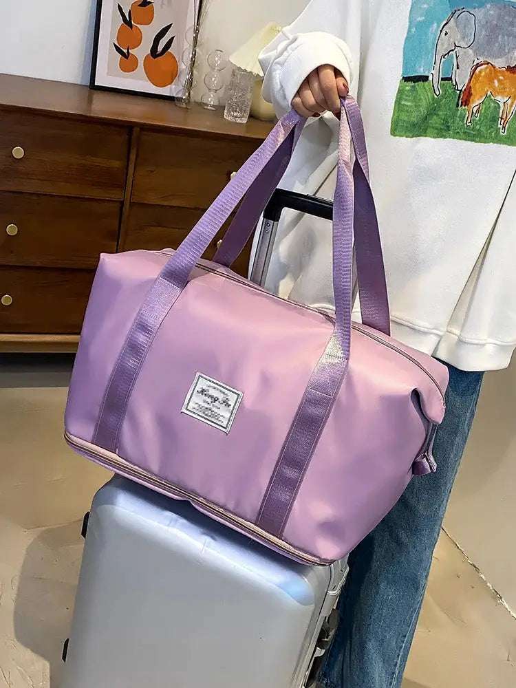 Carry-on travel duffle bag in pink nylon with purple handles, waterproof, large capacity
