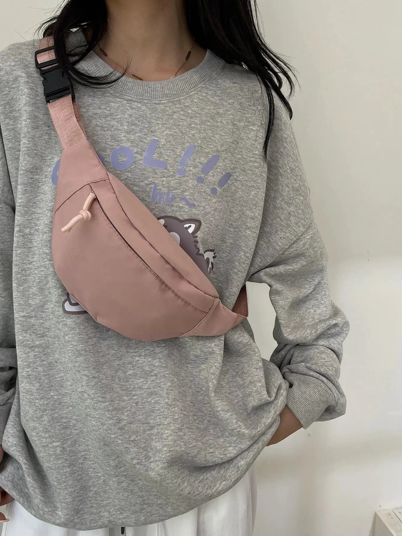 Rose-pink fanny pack worn across chest with adjustable strap