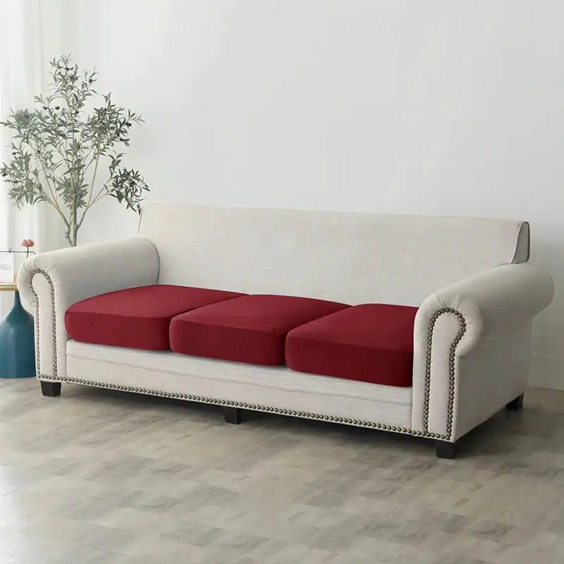 Plush sofa slipcover on beige sofa with three red seat cushions; anti-slip elastic fit