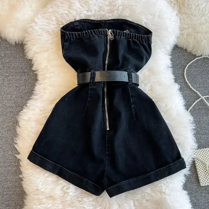 Simples Market black denim off-shoulder romper with belt and front zipper, wide-leg shorts.