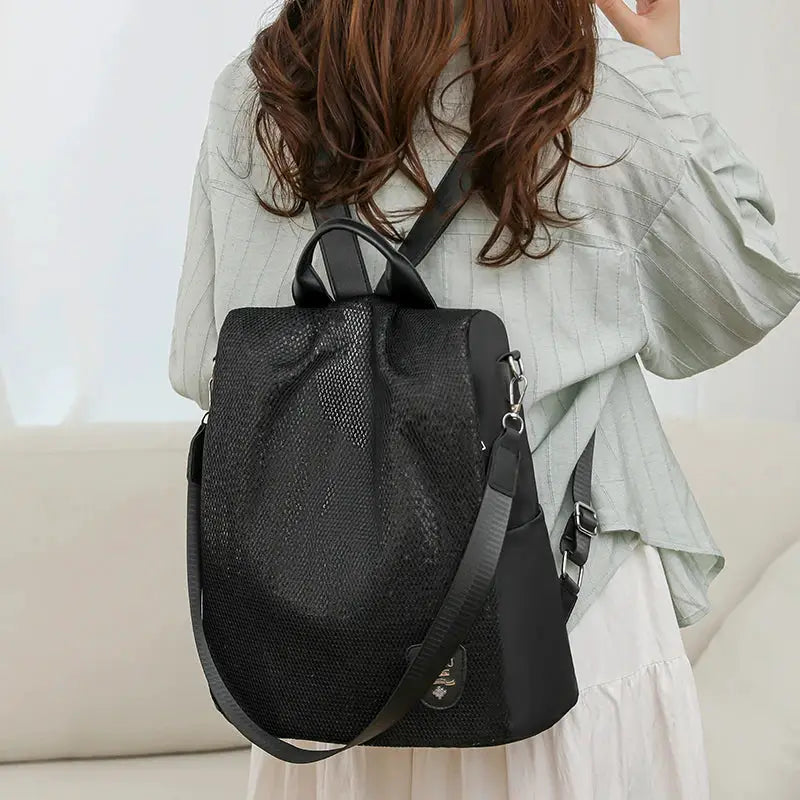 Simples Market women's anti-theft backpack with adjustable strap, black mesh exterior, large-capacity travel bag