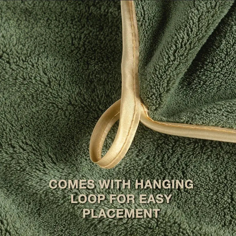 Green plush cotton bath towel with beige hanging loop for easy placement