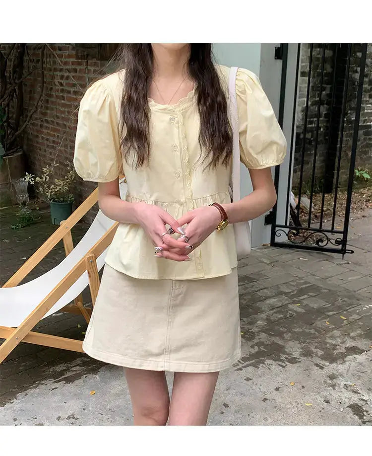 Cream puff-sleeve blouse with peplum and button-front detail, paired with beige skirt