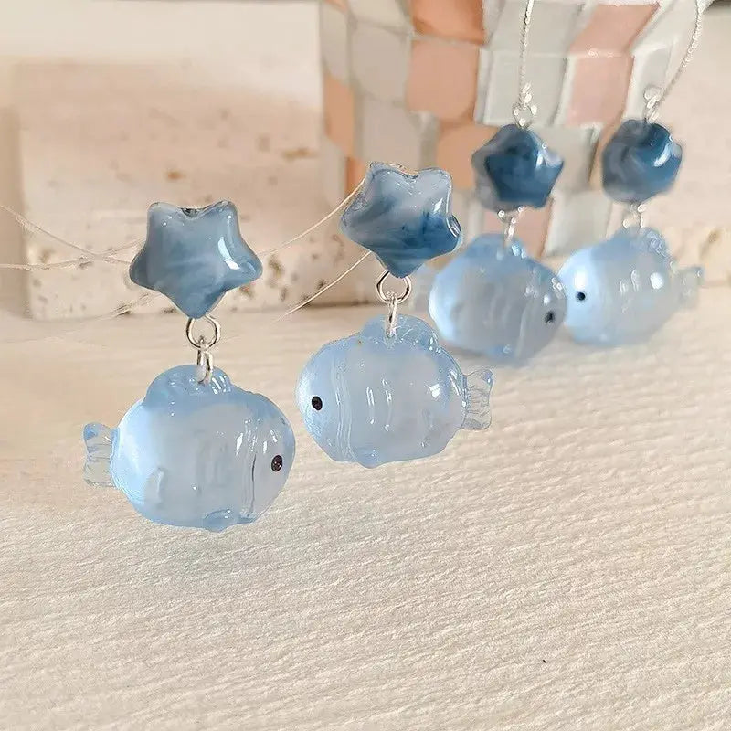 Goldfish pendant earrings in blue translucent resin with star-shaped beads, drop design