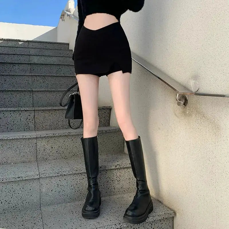 Black split mini skirt for women with high waist and side slit, paired with knee-high boots