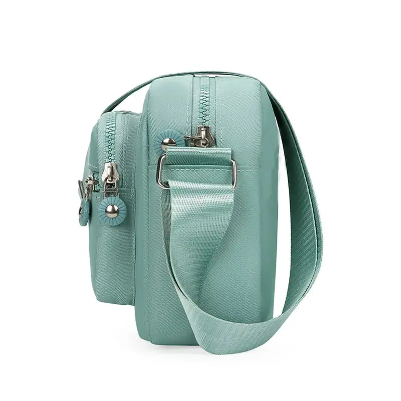 Simples Market mint green crossbody bag with multiple zipper pockets and adjustable strap