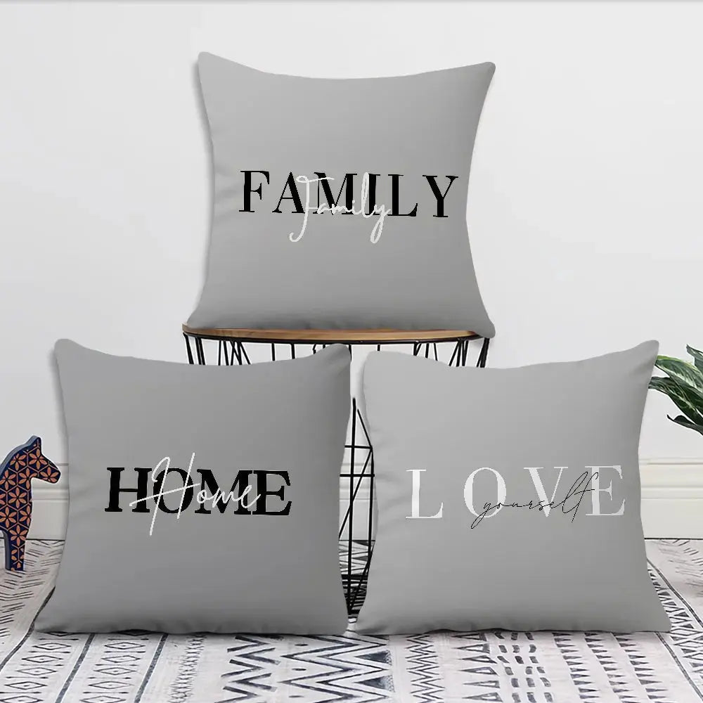 Gray decorative pillow covers set with black and white word art reading FAMILY, HOME, LOVE