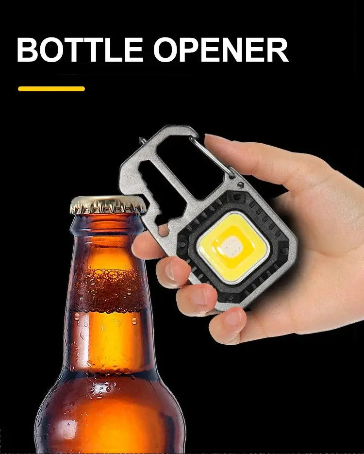 COB keychain work light with carabiner; black housing, yellow LED, 1 light and 1 bottle shown