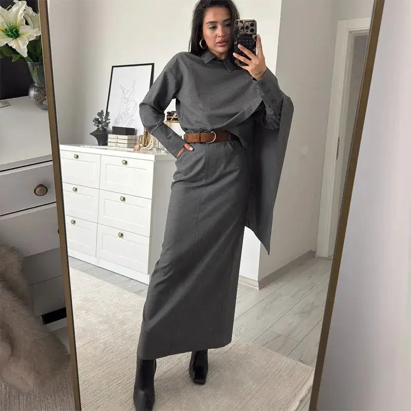 Grey women's blazer suit set with cape-style blouse and long belted skirt, knee-high black boots