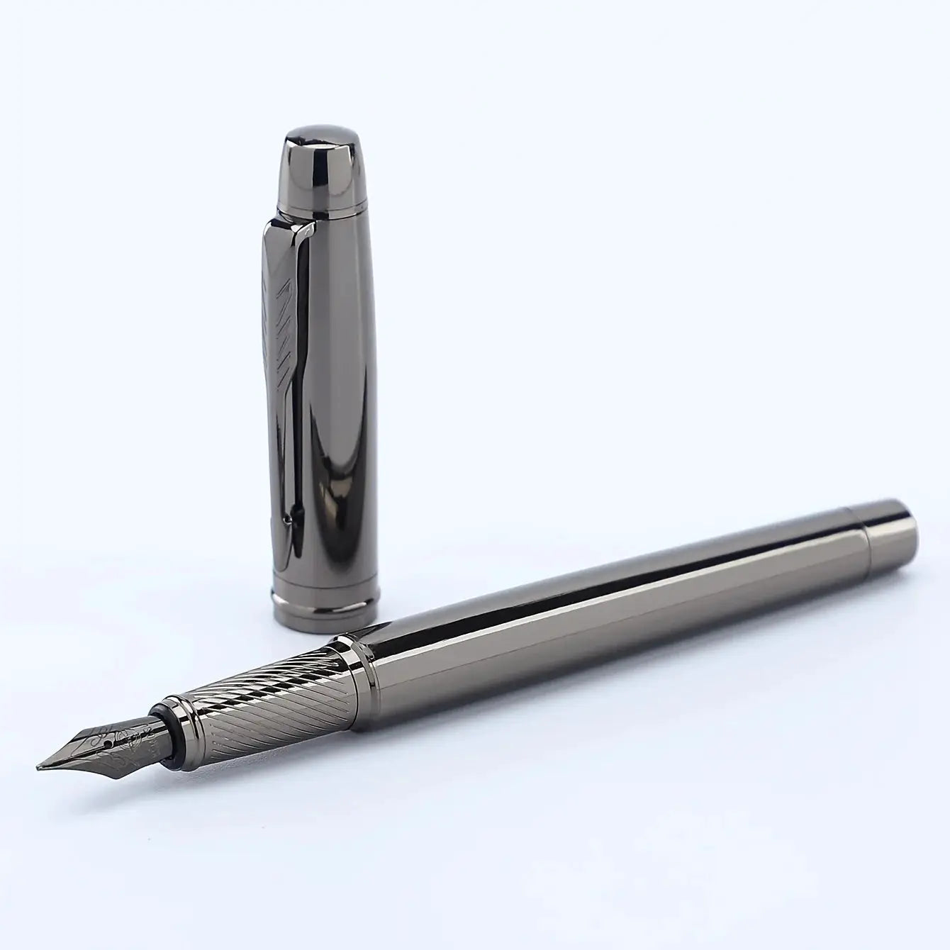 Silver metal fountain pen with chrome finish and exposed nib; cap stands upright beside it.