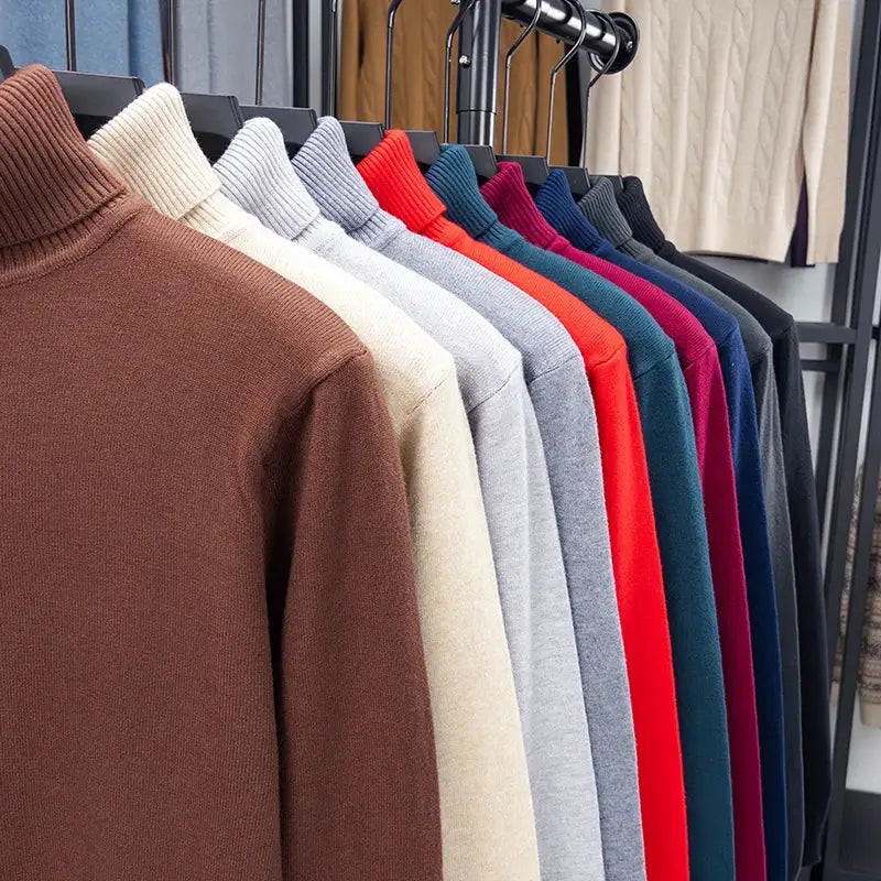 Men's knitted turtleneck sweaters on a rack in multiple colors, front brown, beige, gray, red, teal, blue, purple and black.